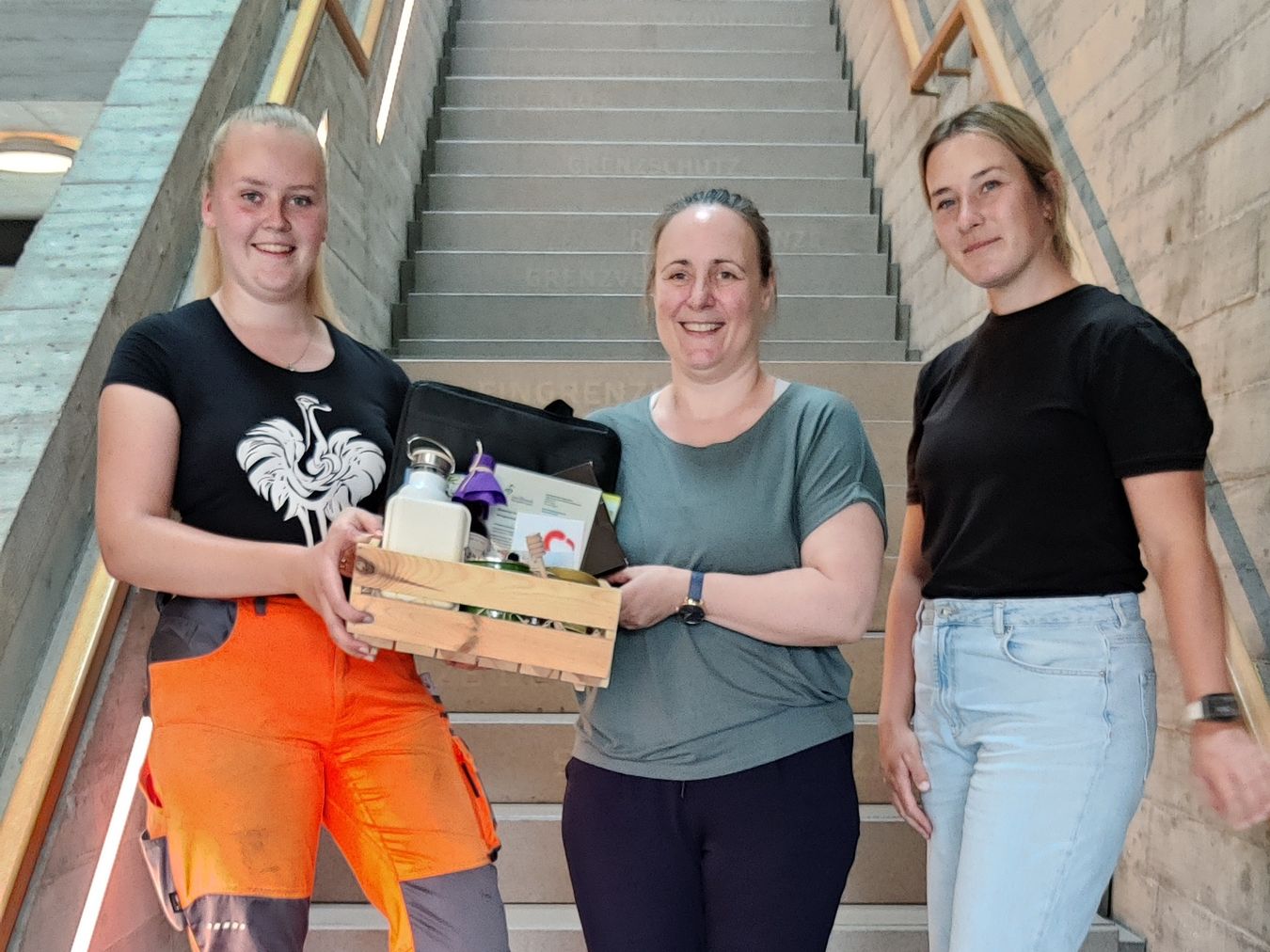 Nicole Wessels überreicht den Geschenkkorb an die Gewinnerinnen Hannah Robers und Theresa Breuer.