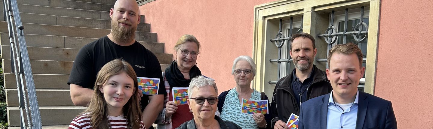 Mitglieder der Initiative „VREDEN BLEIBT BUNT“ übergeben die Wünsche, Fragen und Anregungen der Vredenerinnen und Vredener auf der Burgtreppe an den Bürgermeister Dr. Tom Tenostendarp.