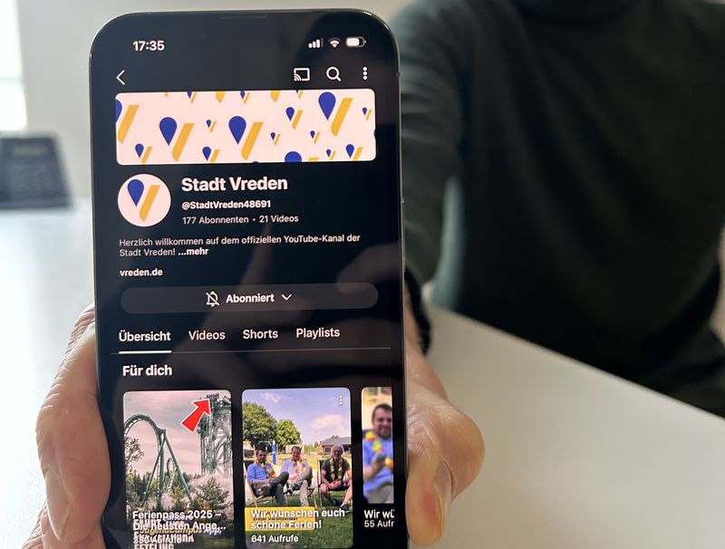 Michael terhörst hält ein Handy mit dem geöffneten YouTube-Kanal der Stadt Vreden nach vorne.