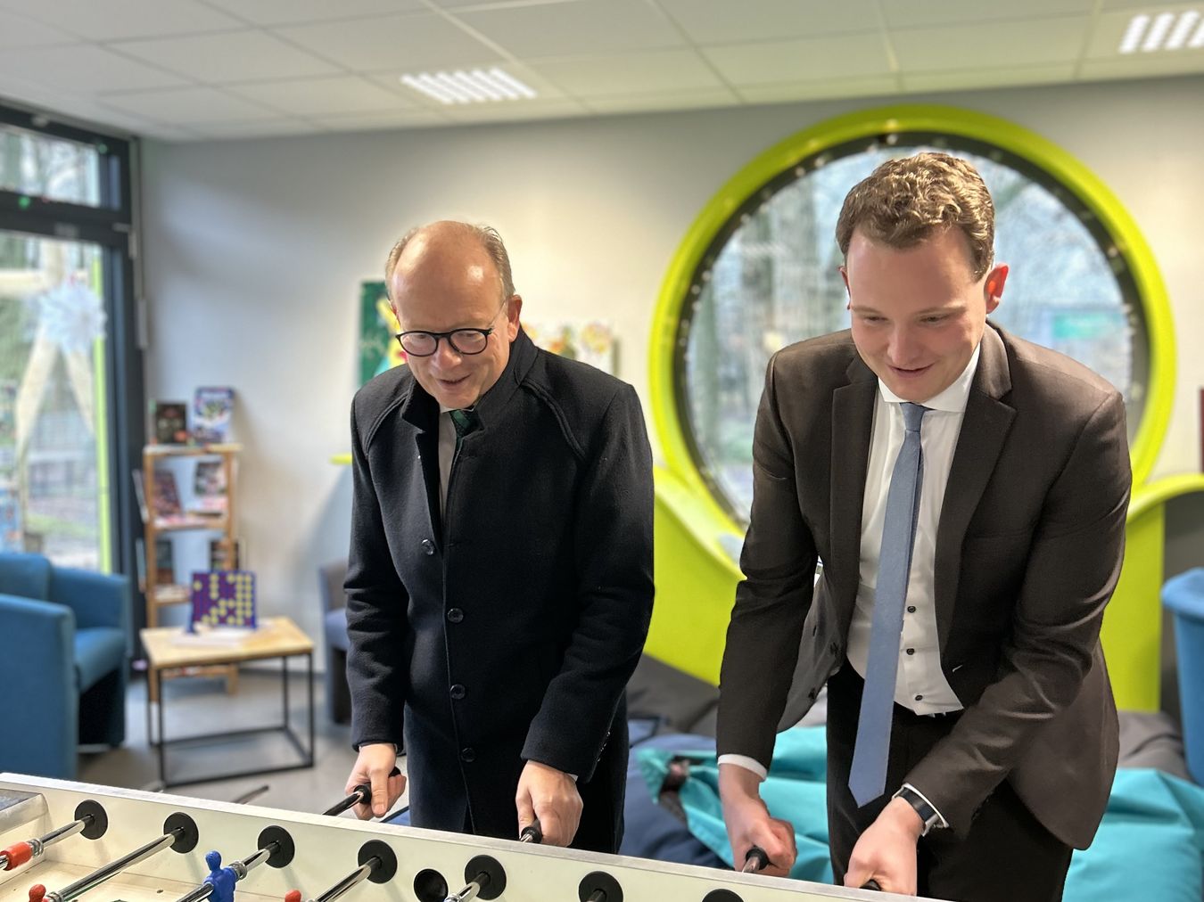 Landtagspräsident André Kuper (links) steht zusammen mit Bürgermeister Dr. Tom Tenostendarp an einem Kicker