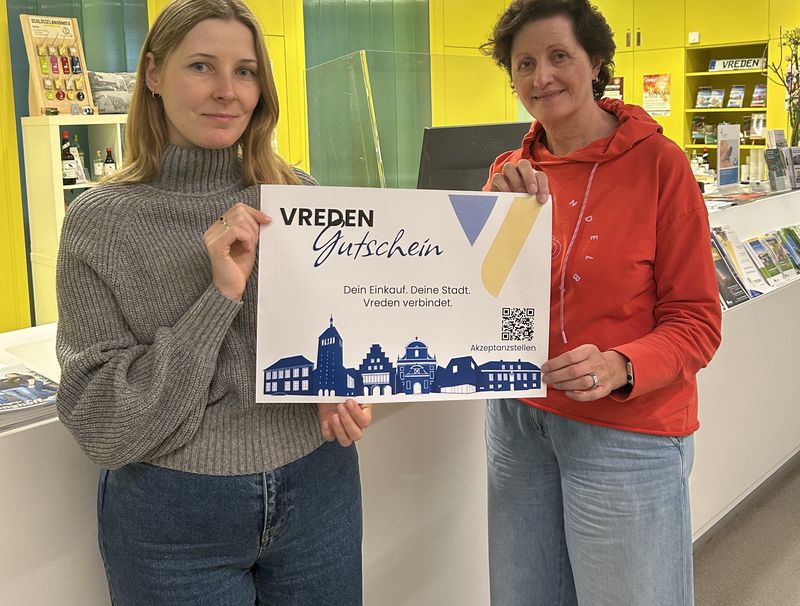 Karina Woźniak-Arends (links) und Gisela Busch präsentieren das neue Design des Vreden-Gutscheins.