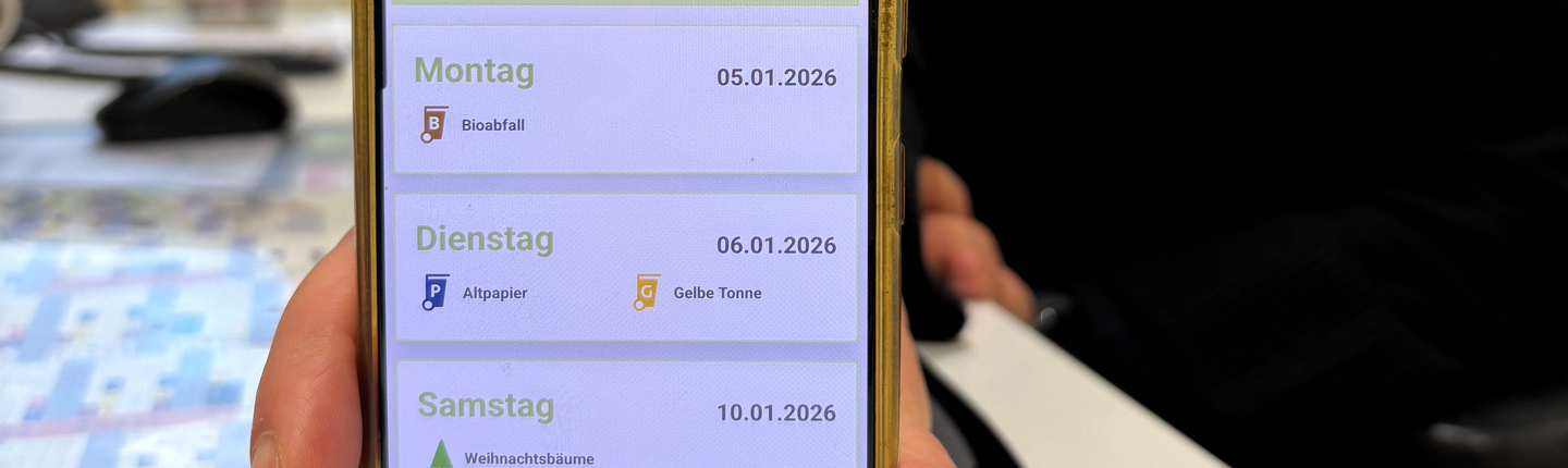 Eine Frau hält eine Handy mit der geöffneten EGW App in die Kamera