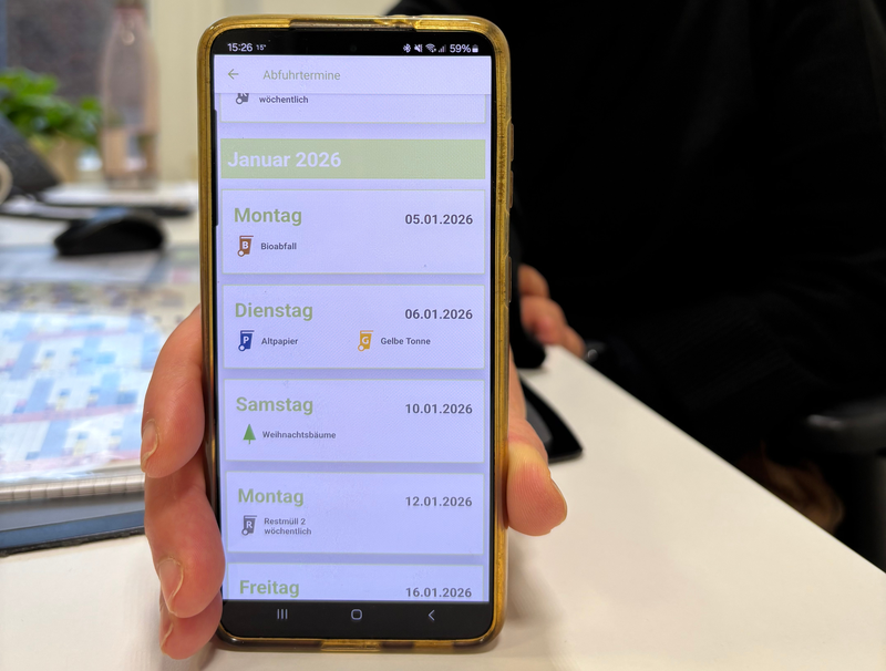 Eine Frau hält eine Handy mit der geöffneten EGW App in die Kamera