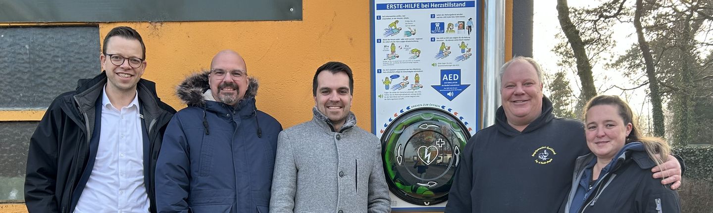 Der neue Defibrillator am Angelparadies Zwillbrock. Im Bild (v. l.) Benedikt Bengfort und Markus Temminghoff, Volksbank Gronau-Ahaus eG, Fadi Rajab, Erster Beigeordneter der Stadt Vreden, Andreas Kleinhaus, Geschäftsführer des Angelparadieses, und seine Frau Severin.
