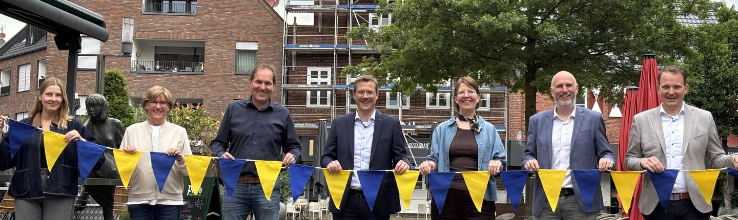 Gemeinsam für eine attraktive Innenstadt: Die Sponsoren präsentieren die neuen Wimpel, die das Stadtbild verschönern (vlnr.): Karina Woźniak-Arends (Stadtmarketing), Margot Isfording (Papierfabrik Vreden GmbH), Thomas Hackfort (Matthews Engineering), Hendrik Pieper (Saueressig), Eva-Maria Imping (Vredener Wirtschaftsvereinigung), Markus Thesing (Vredener Wirtschaftsvereinigung), Bürgermeister Dr. Tom Tenostendarp (Stadt Vreden).