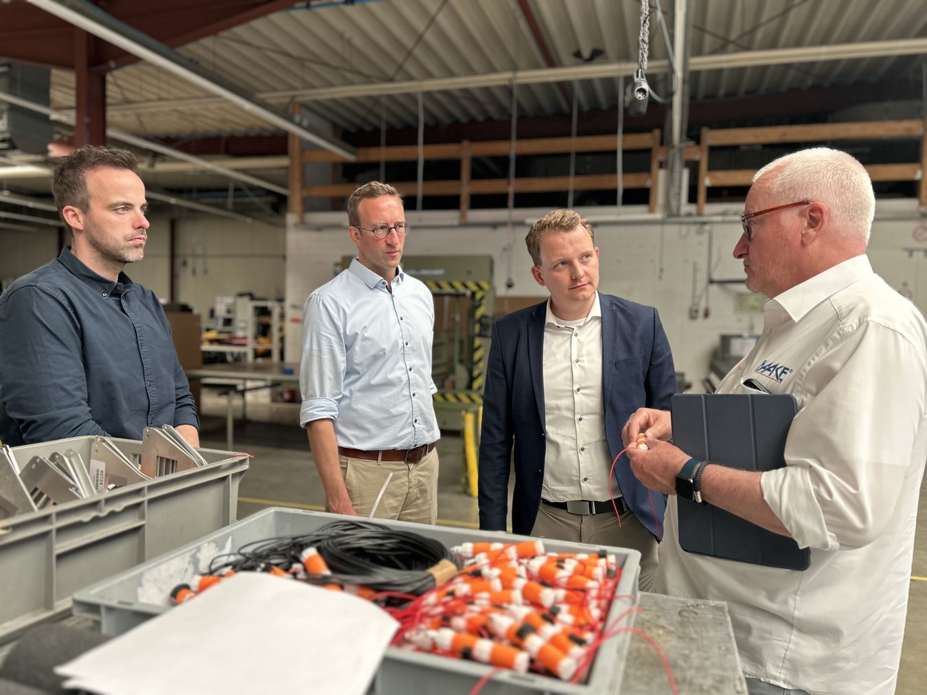 Die Geschäftsführer André (rechts) und Jonas Haake (links) führen Wirtschaftsförderer Michael Terhörst (Mitte links) und Bürgermeister Dr. Tom Tenostendarp (Mitte rechts) über das Firmengelände.