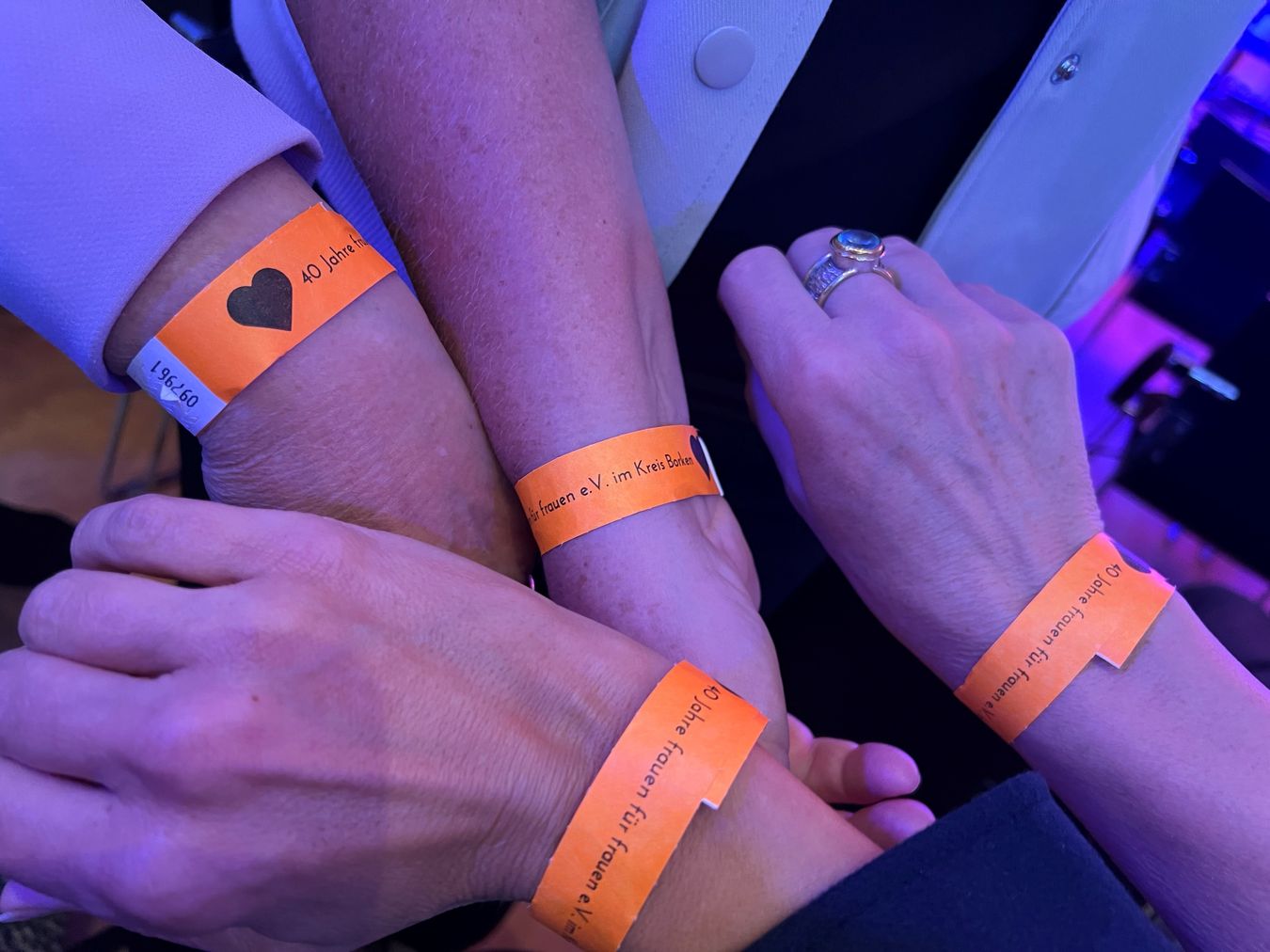 Arme von Teilnehmenden mit Armband zur Veranstaltung