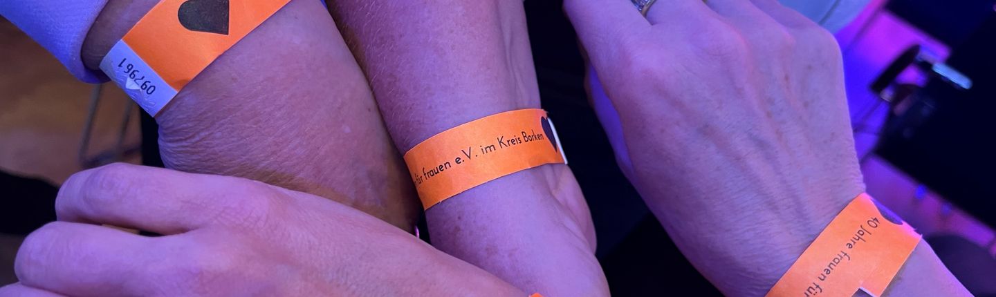 Arme von Teilnehmenden mit Armband zur Veranstaltung