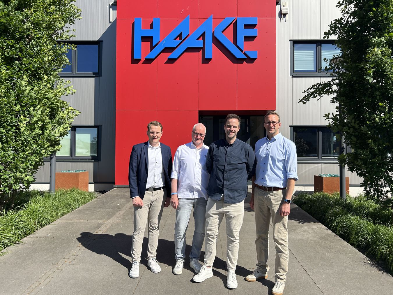 Es stehen vor dem Haake.Firmenlogo (v.l.n.r.): Bürgermeister Dr. Tom Tenostendarp, Geschäftsführer André Haake, Geschäftsführer Jonas Haake und Wirtschaftsförderer Michael Terhörst.