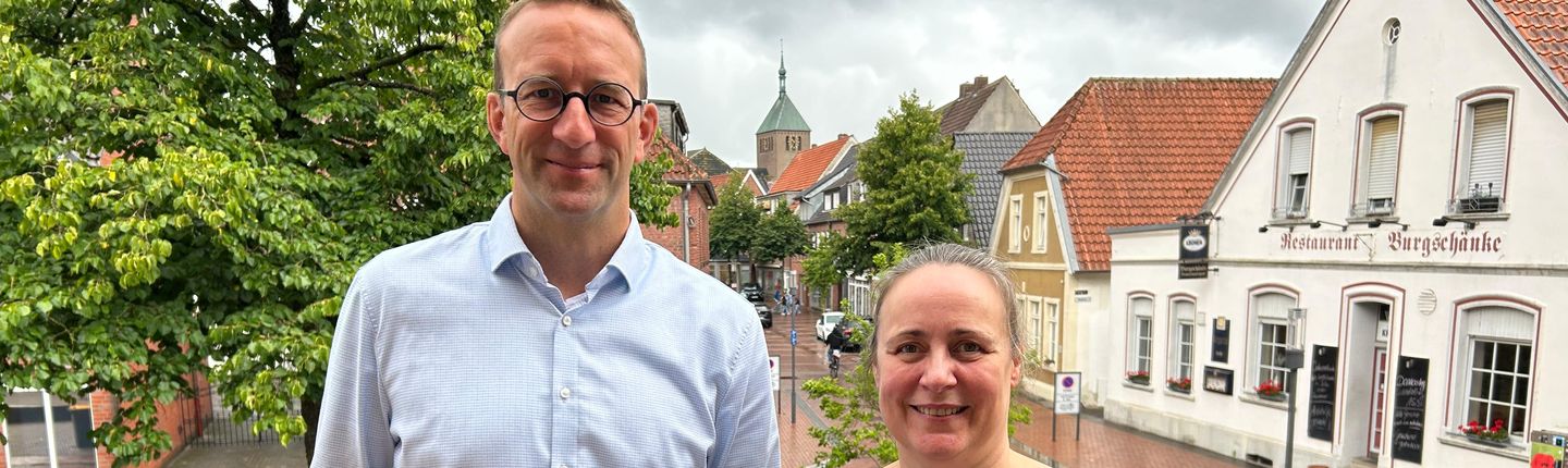 Nicole Wessels und Michael Terhörst vom Stadtmarketing mit den Papiertüten, die das Stadtmarketing eigens für den ersten Frauen- und Mädchenflohmarkt in Vreden entworfen hat, oben auf der Rathaustreppe.