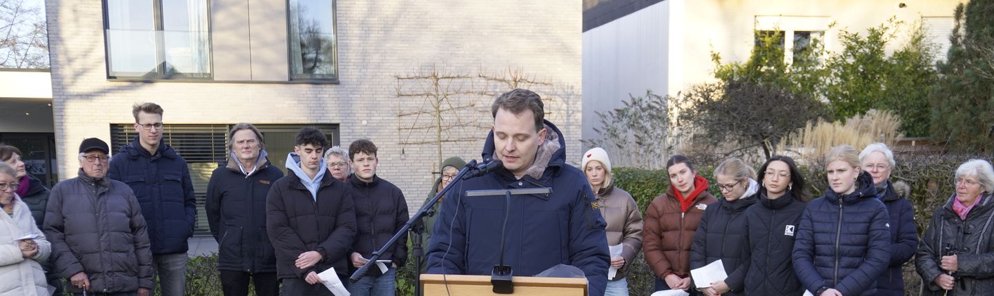 Bürgermeister Dr. Tom Tenostendarp steht an einem Pult vor einer Gruppe Vredenerinnen und Vrednener und hält eine Rede zum Jahrestag der Befreiung Auschwitz