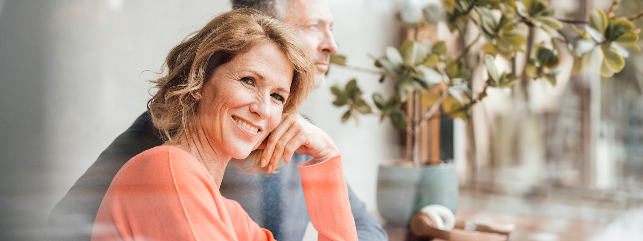 Eine Frau mittleren alters lächelt freundlich in die Kamera