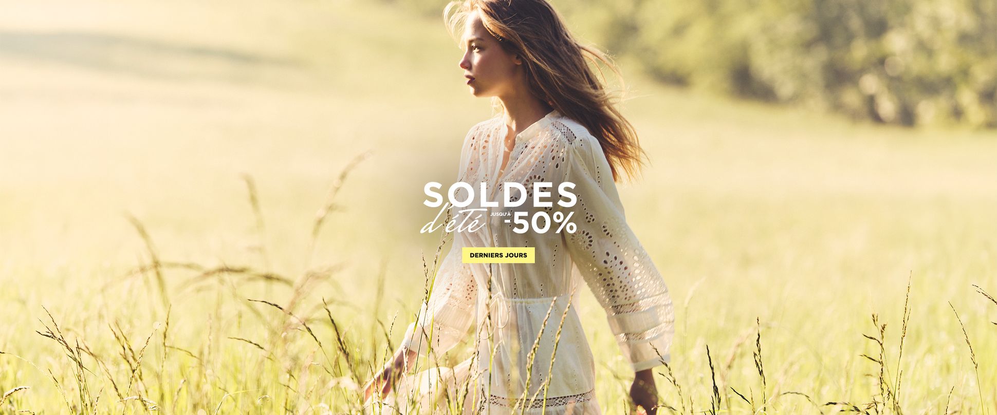 Woman in a white dress walking through a sunlit field, with text overlay offering a 50% summer sale in French.