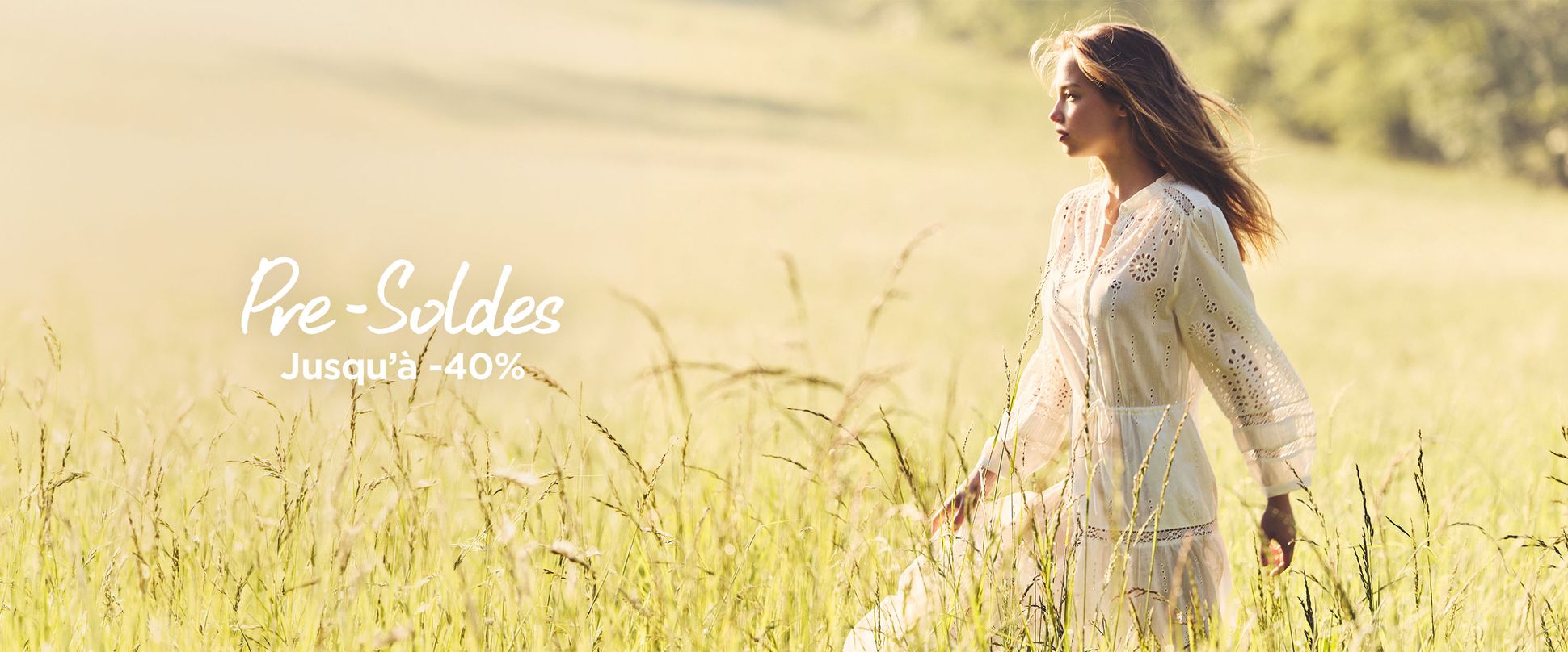 Woman in a white dress walking through a sunlit meadow, with "Pre-Soldes Jusqu'à -40%" text on the left side.