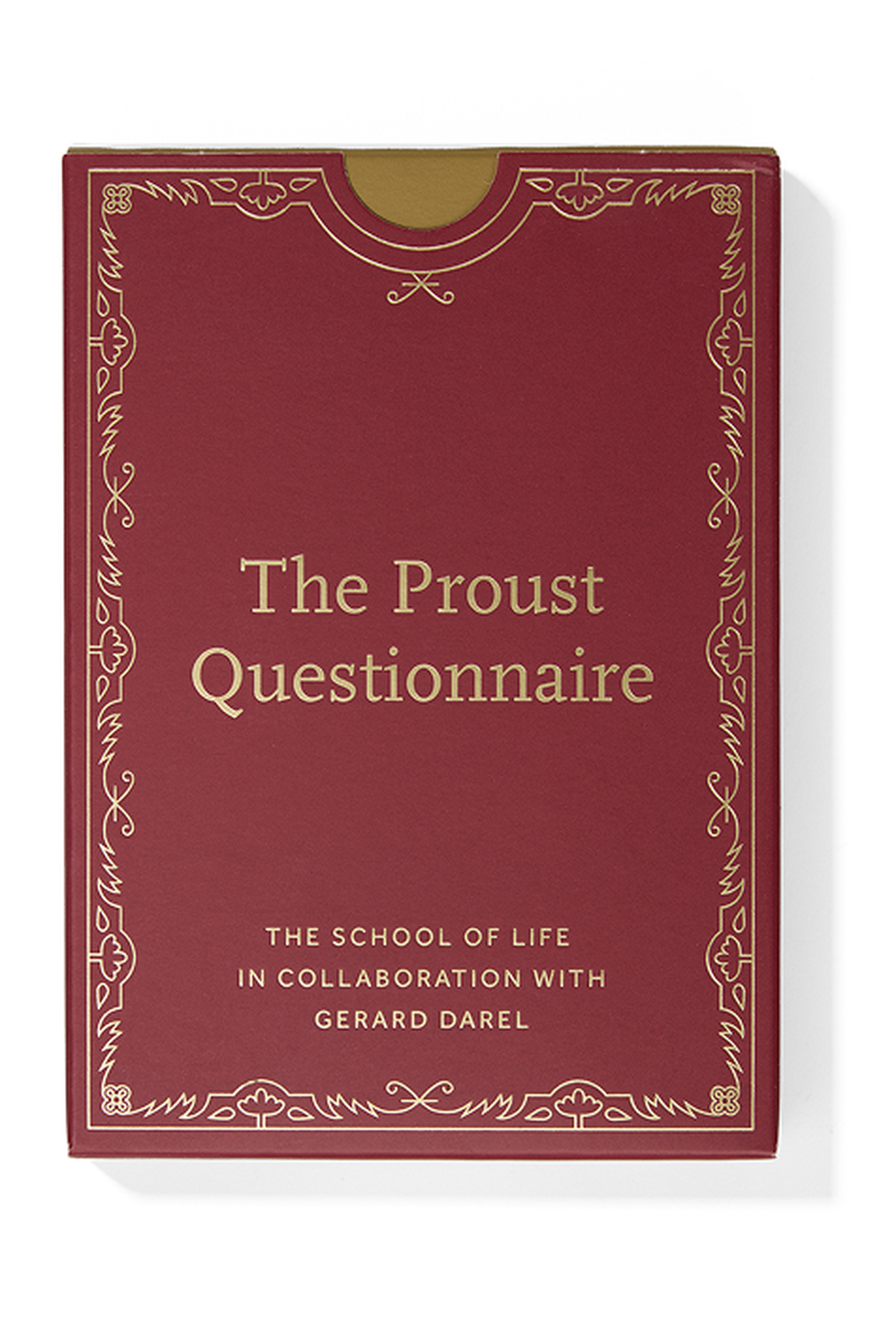 Red book cover titled "The Proust Questionnaire," with ornate gold detailing and text, by The School of Life in collaboration with Gerard Darel.
