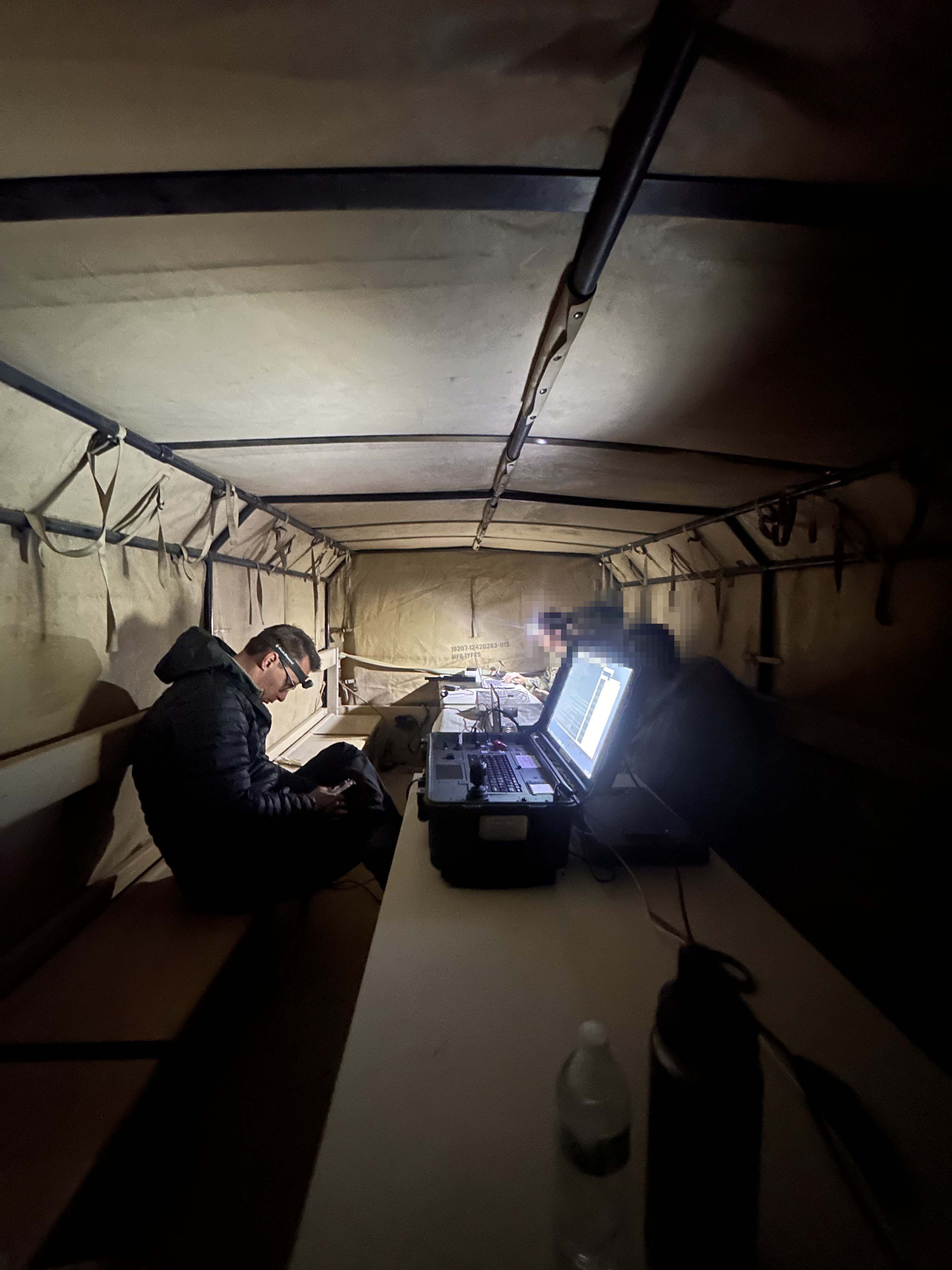 Soldiers operate P8 hybrid drone within combat vehicle at night