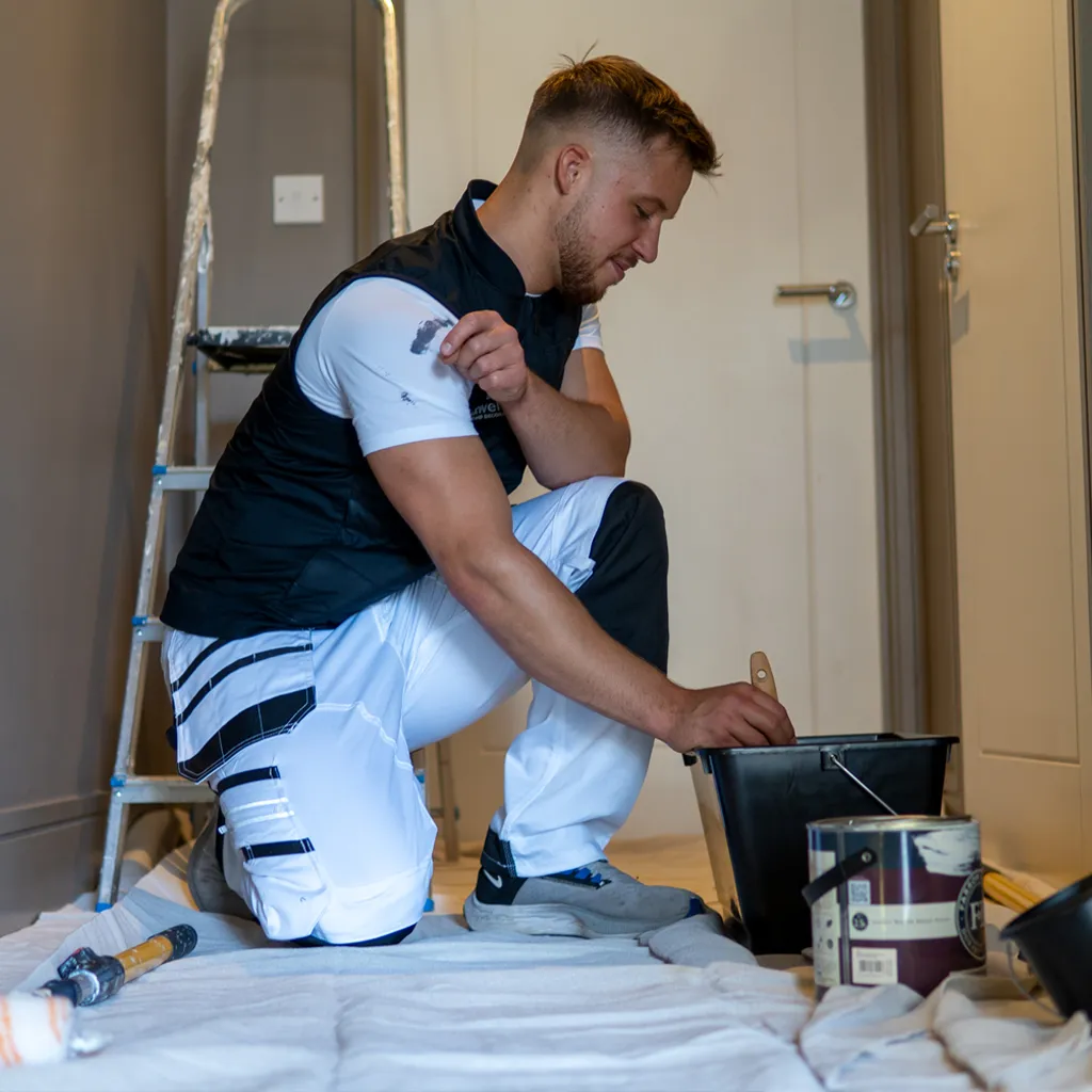Painter in hallway with paintbrush