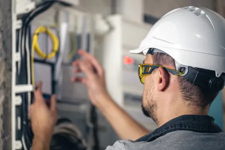 Man Electrical Technician Working Switchboard With Fuses