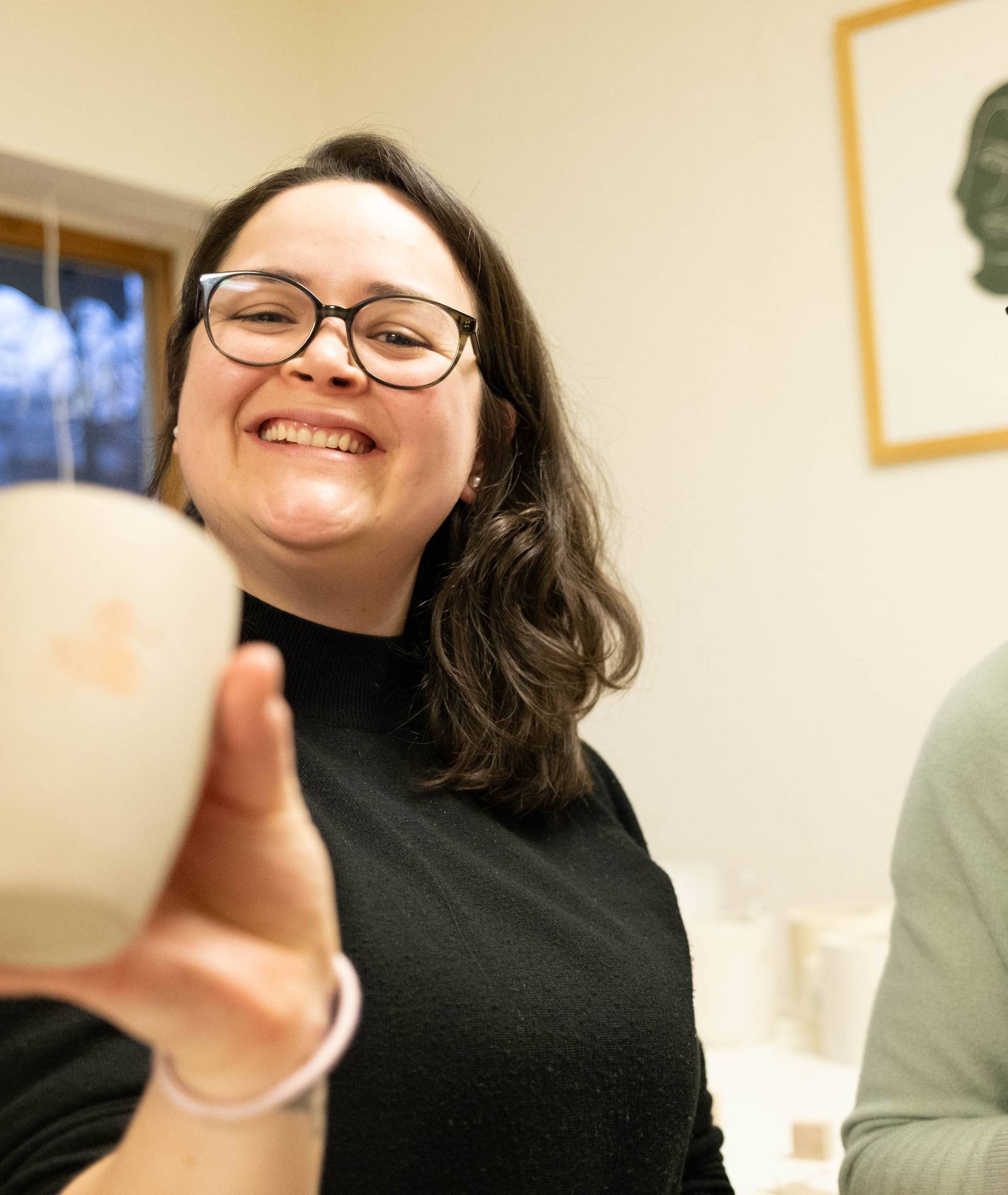 Natali und Elin lachen, Natali zeigt ihre getöpferte Tasse.