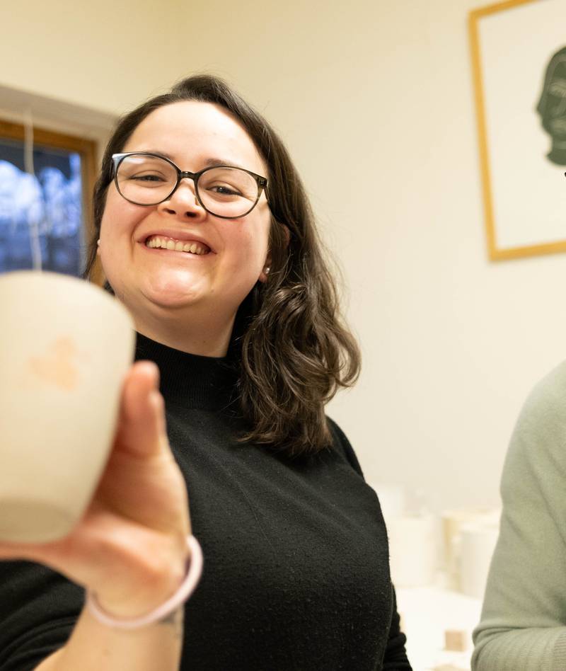 Natali und Elin lachen, Natali zeigt ihre getöpferte Tasse.