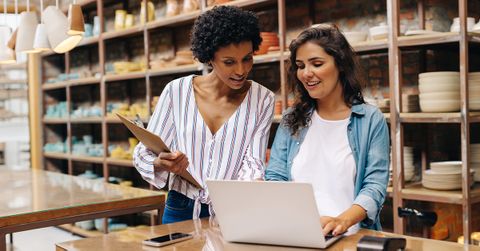 business partners working on their laptop in their warehouse