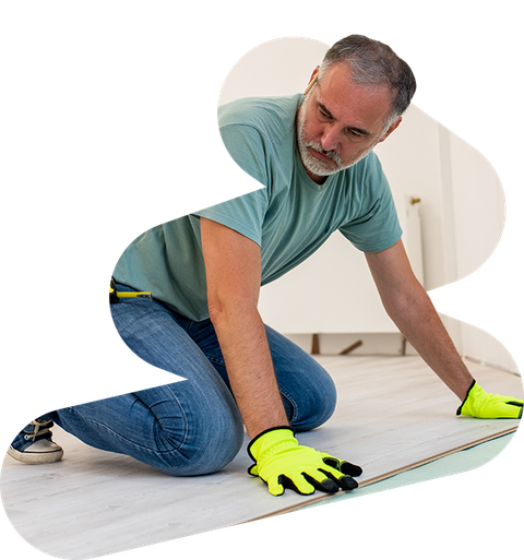 contractor wearing bright yellow safety gloves fitting a custom floor
