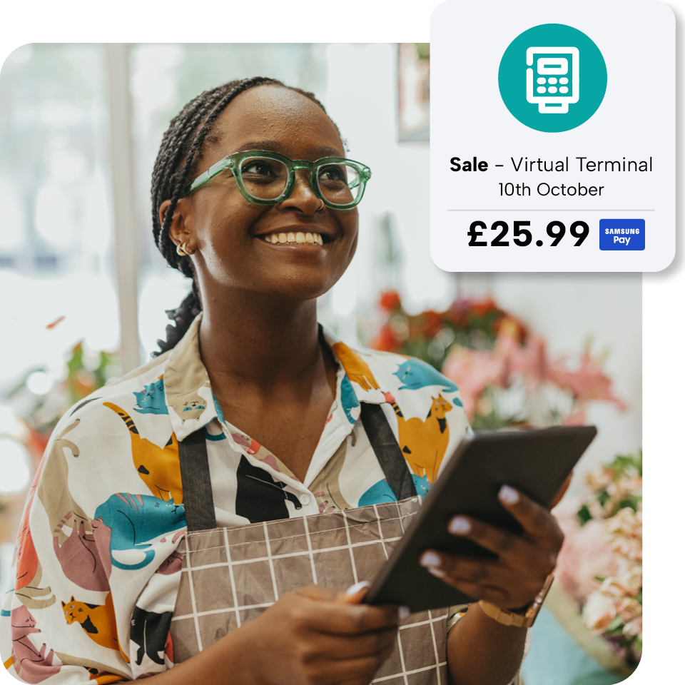 Smiling woman in apron holds tablet in flower shop. Overlay shows a virtual terminal sale for £25.99 on 10th October.