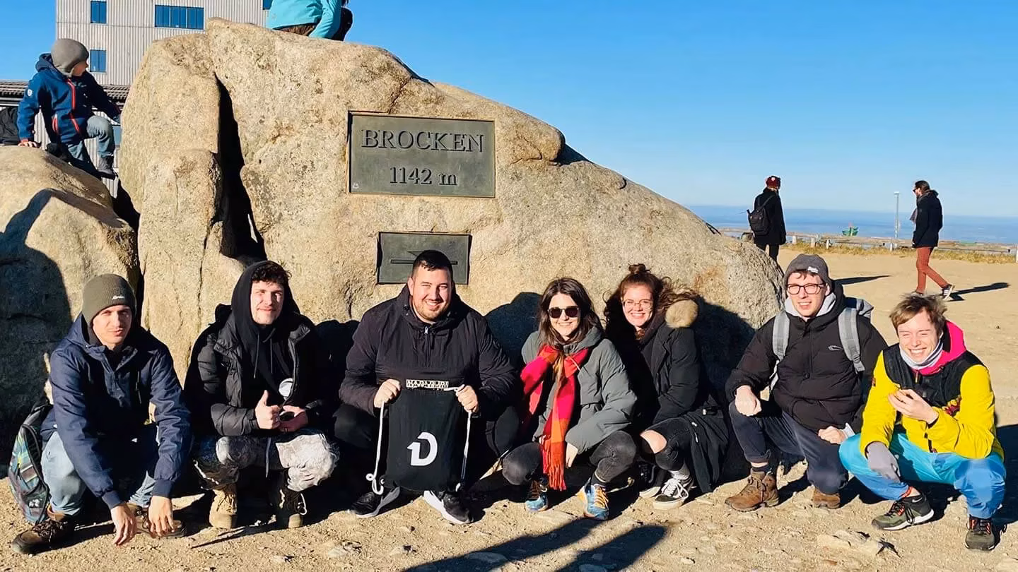 Team posiert auf Brocken Gipfel im Harz