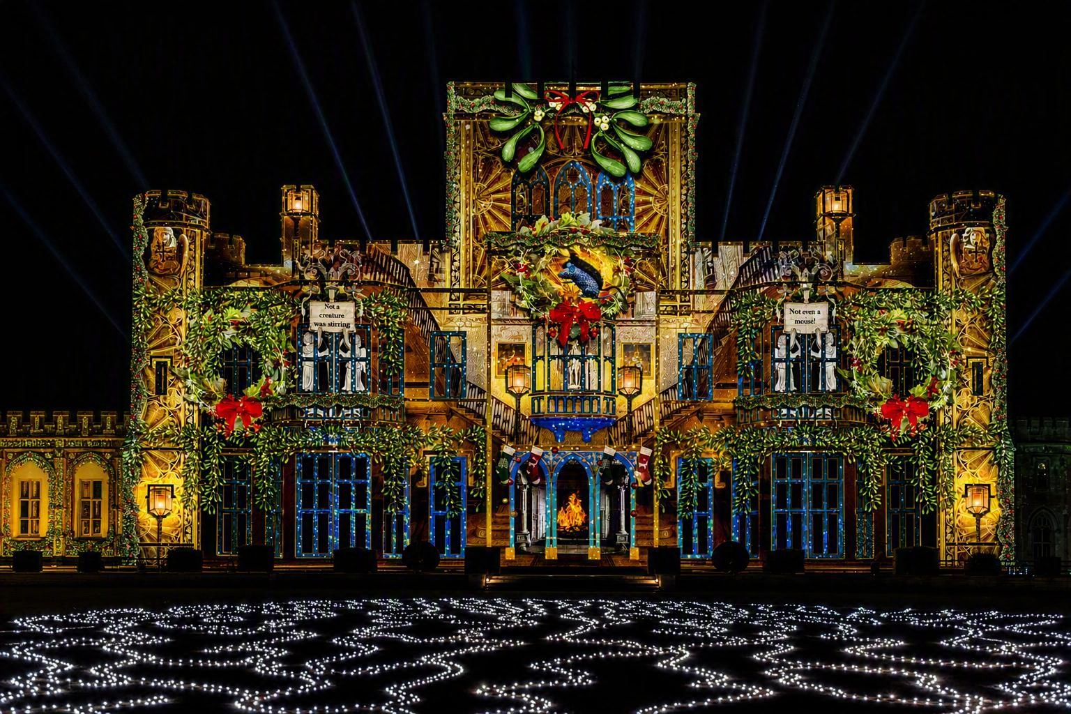 A castle illuminated at night with festive Christmas lights and decorations, creating a colorful and vibrant holiday atmosphere.