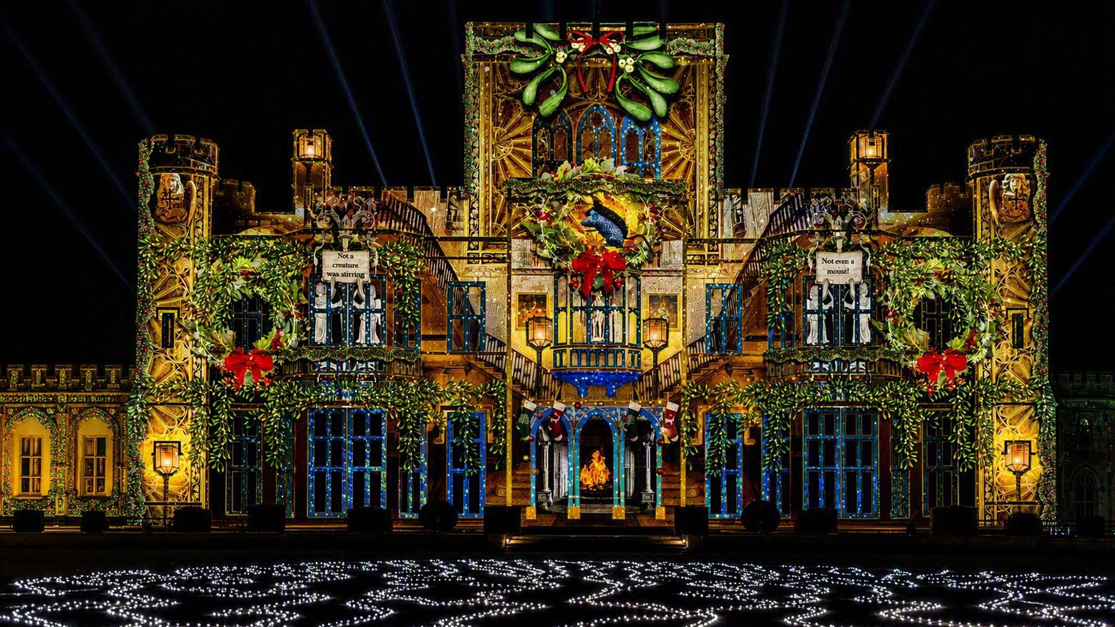 A castle illuminated at night with festive Christmas lights and decorations, creating a colorful and vibrant holiday atmosphere.