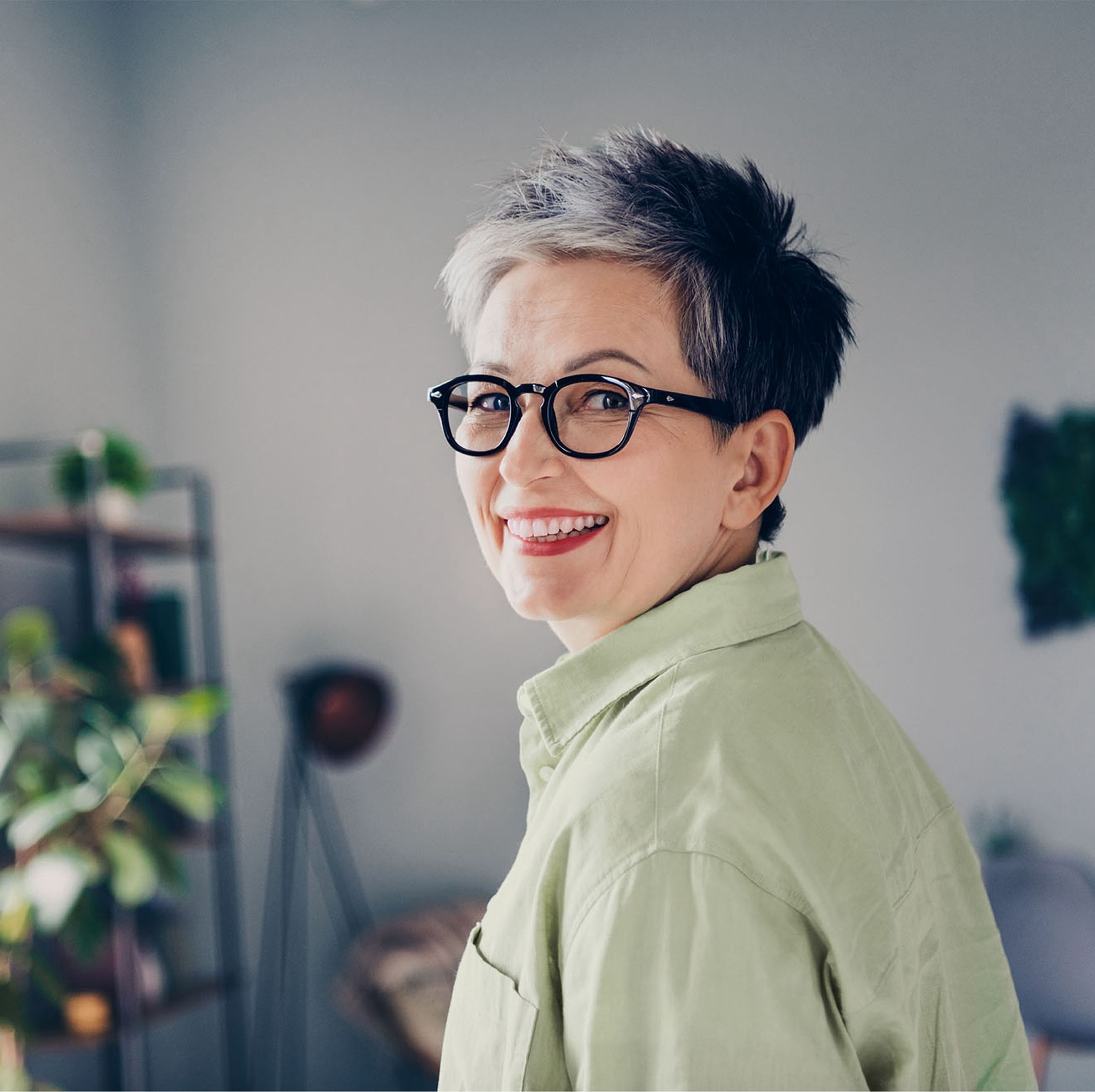 Frau Ende 50 blickt lächelnd in die Kamera