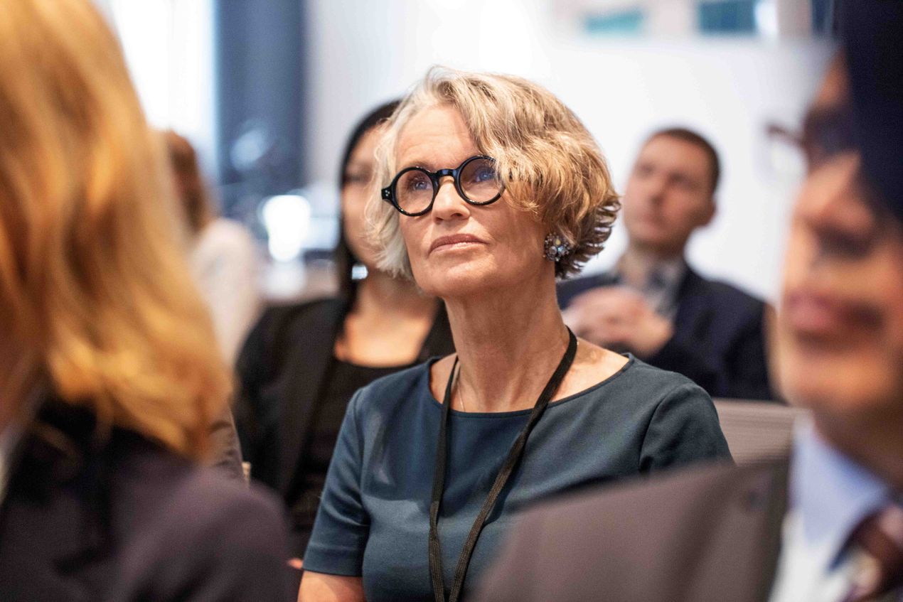 Frau hört bei einem Vortrag zu