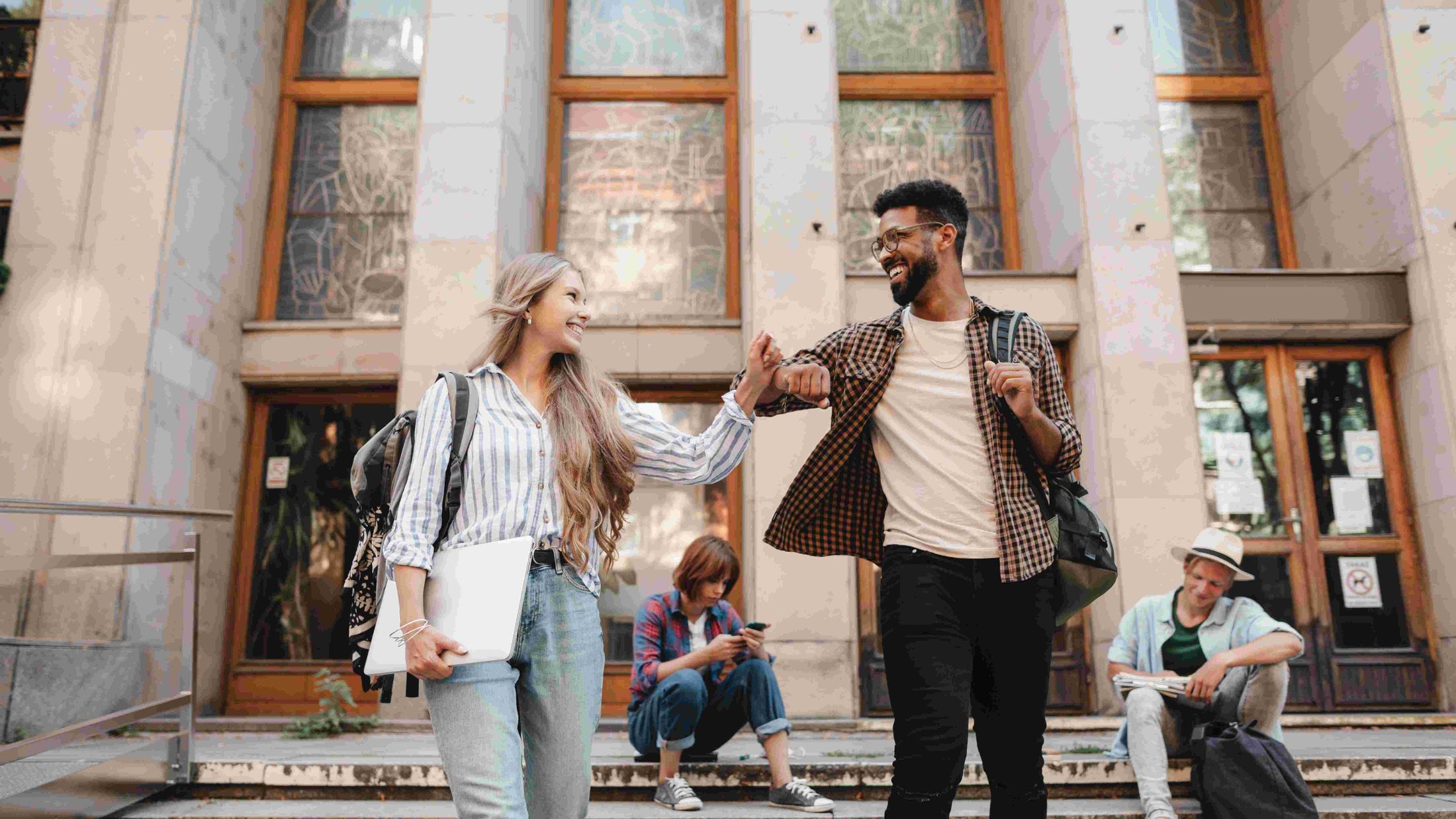 Junge Frau und junger Mann verlassen ein Gebäude
