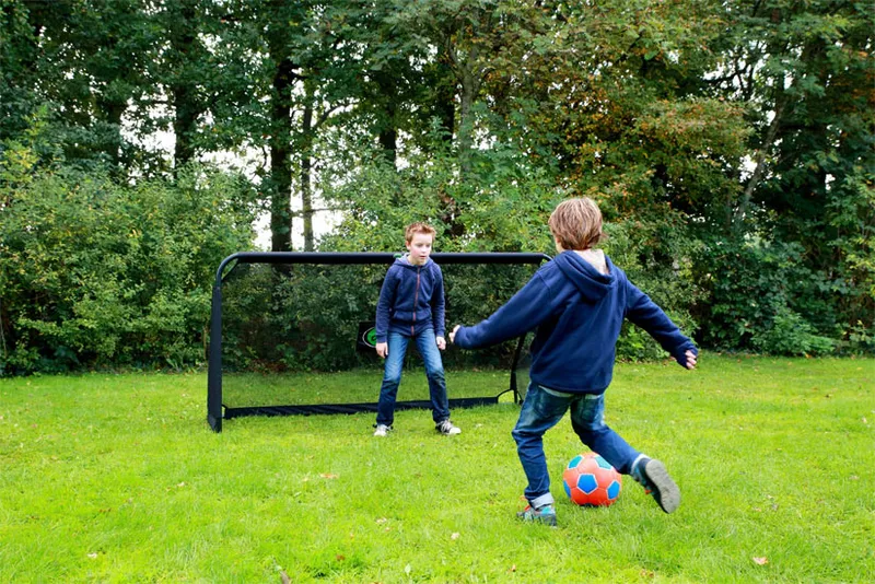 Enfants jouant au football dans le jardin