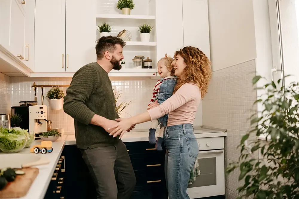 young family having fun and laughing in their kitchen at home