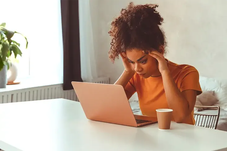 frustrated young first time buyer in front of laptop confused about the elements and process of moving home