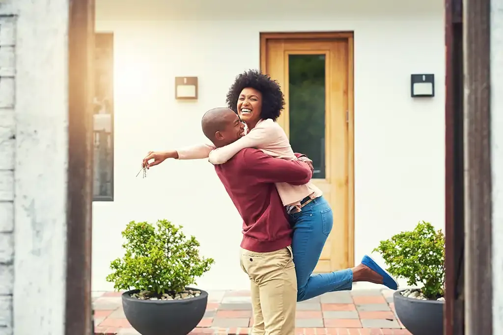 first time buyers celebrating moving into their home after using the mortgage guarantee scheme to help them buy