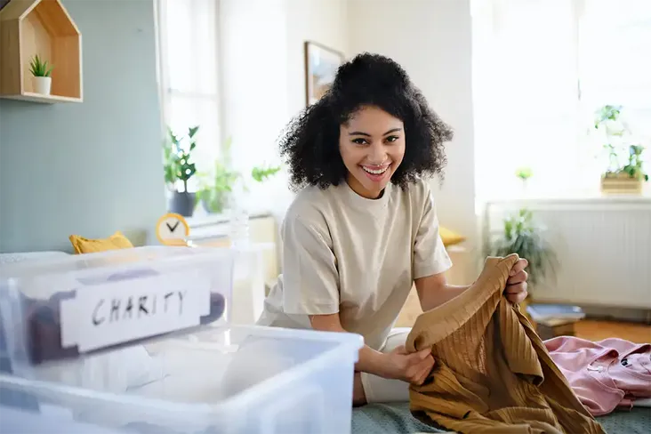young girl sorting through her items and decluttering to help make her home move eco-friendly