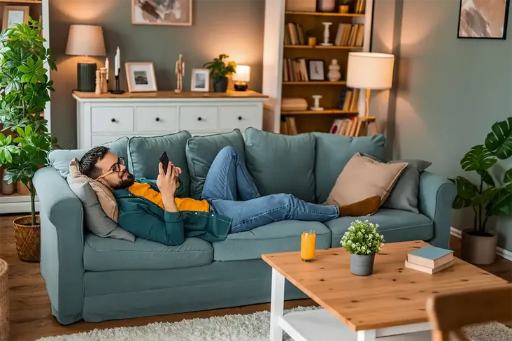 man on sofa happy his mortgage offer got approved