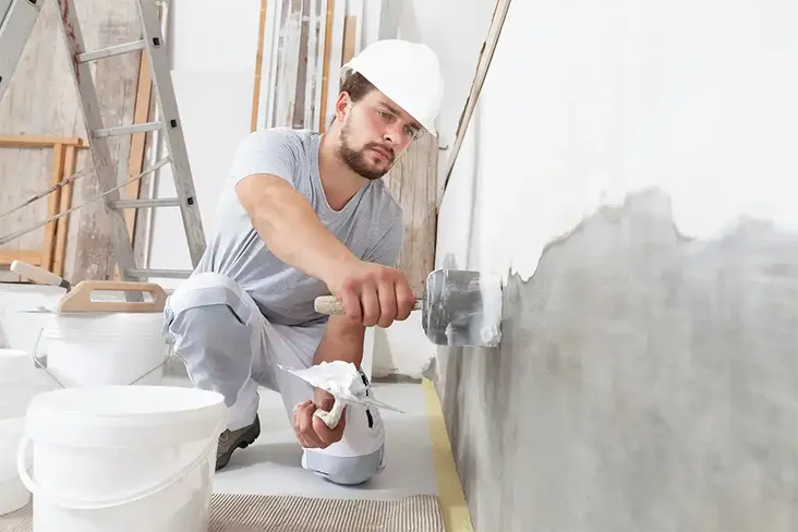 builder plastering his renovation property bought through auction