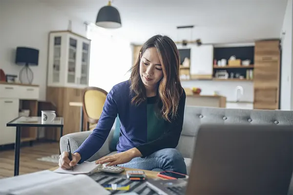 young woman working out her finances to see if she can buy a house on her own