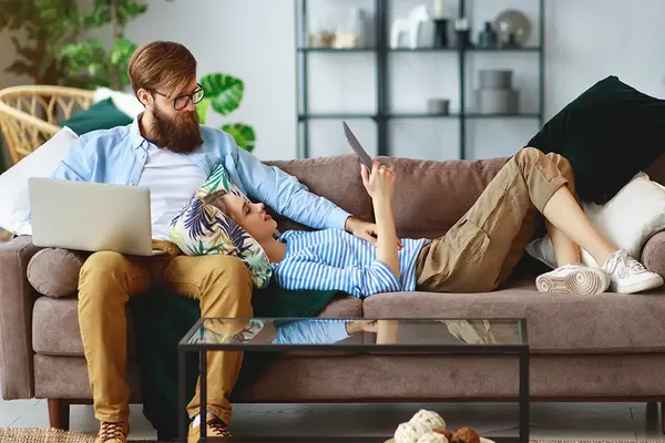 young couple relaxing in their flat looking at the cost to sell their flat with a short lease