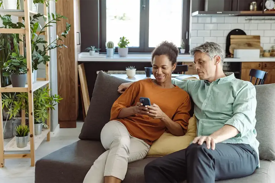 mature couple comparing remortgage conveyancing quotes on their smartphone