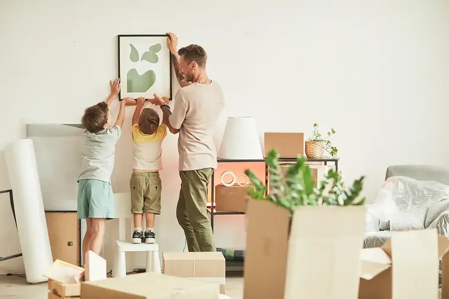 family hanging up wall art in their new home