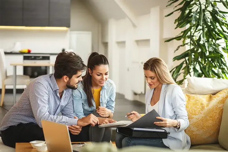 a young couple looking through their estate agents contract before signing