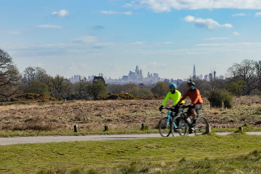 cyclists at ladderstile gate in Richmond Park near Coombe and New Malden, London UK