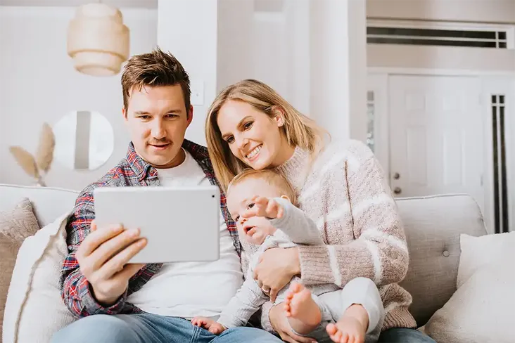 a young family watching a helpful video about what to expect once they instructed their conveyancer