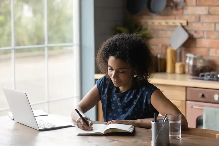 a young lady reviewing the contract for her house purchase writing down questions to ask her conveyancer