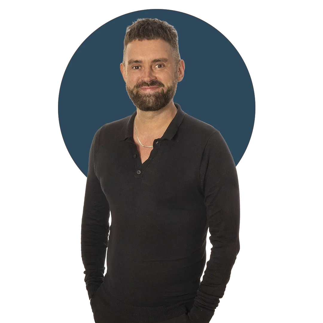 Leon Hart wearing a black long-sleeve shirt stands smiling, with a dark blue circular background.