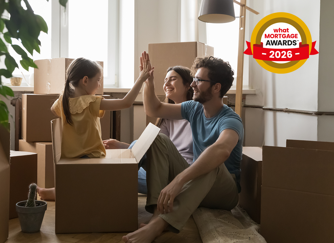 Family high-fiving while sitting among moving boxes in a sunlit room. A "What Mortgage Awards 2026" badge is visible in the corner.